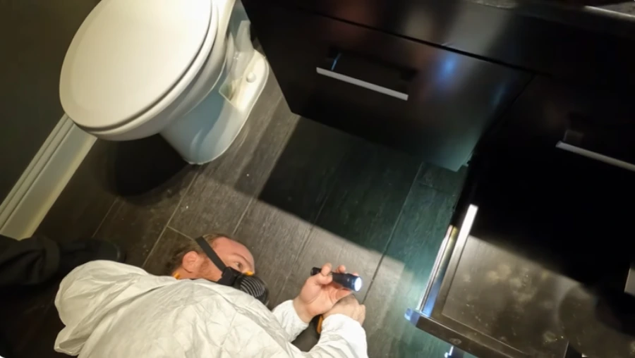 Inspecting a Houston bathroom for hidden mold and moisture behind the walls